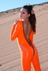 Brunette in orange latex jumpsuit shows her perfect titties