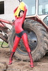 Black haired babe in red latex posing with a tractor