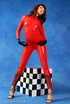 Brunette bombshell in red latex jumpsuit posing with a checked cube