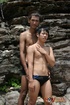 Two skinny Asian dudes wearing black trunks swims at the river then goes
