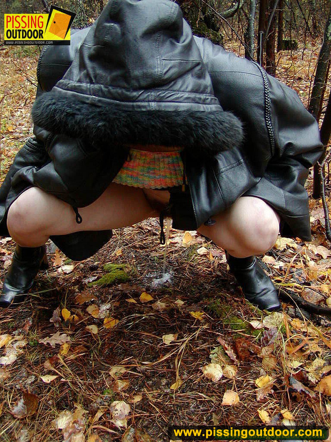 Shy teen wrapped up in a hooded black coat bends down to piss freely in the woods - XXXonXXX - Pic 17