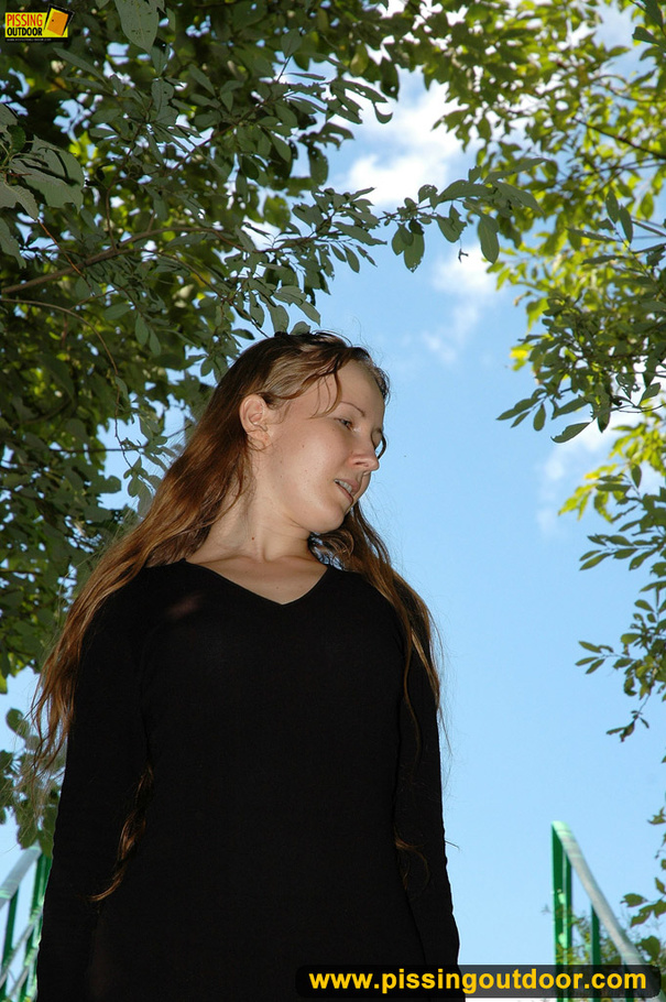 Smiling cute shapely chick in sexy black dress pisses along the park steps - XXXonXXX - Pic 2