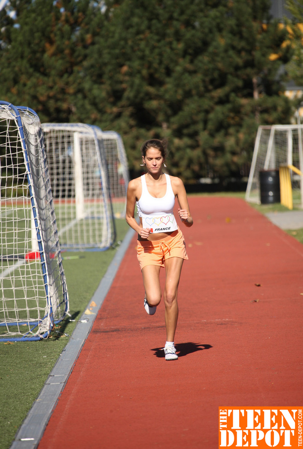 Sweet young runner loves to pose her sexy fit body wearing her tiny white shirt, orange shorts and white rubber shoes in a running field before she goes indoor and expose her small tits. - XXXonXXX - Pic 7