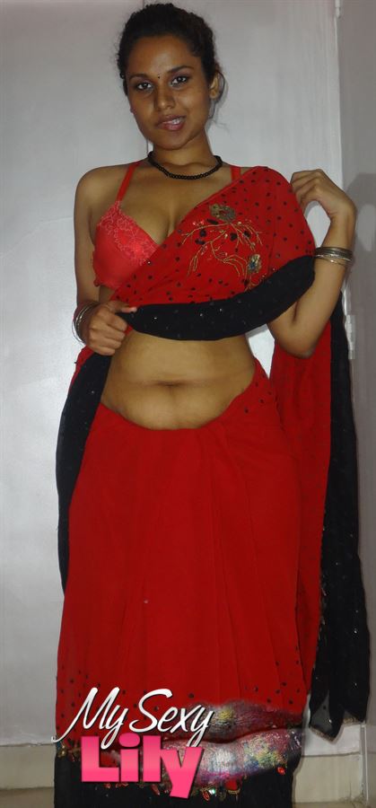 Stunning Indian chick displays her hot curves in red and black dress before she pulls it down and bares her hot tits with big nipples under her red bra on a gray and white bed. - XXXonXXX - Pic 1