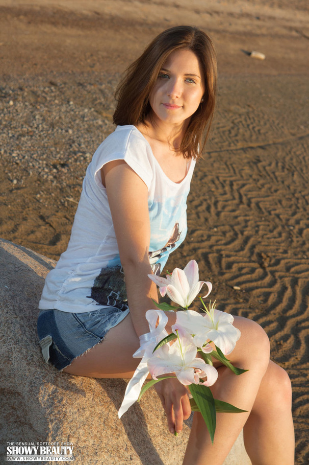 Lovely brunette with steaming hot body strips off her white shirt and jeans shorts then teases with her perfect tits as she pose topless wearing her pink and blue panty before she takes it off and teases with her erotic pussy as she sits naked on a big rock at the beach. - XXXonXXX - Pic 1