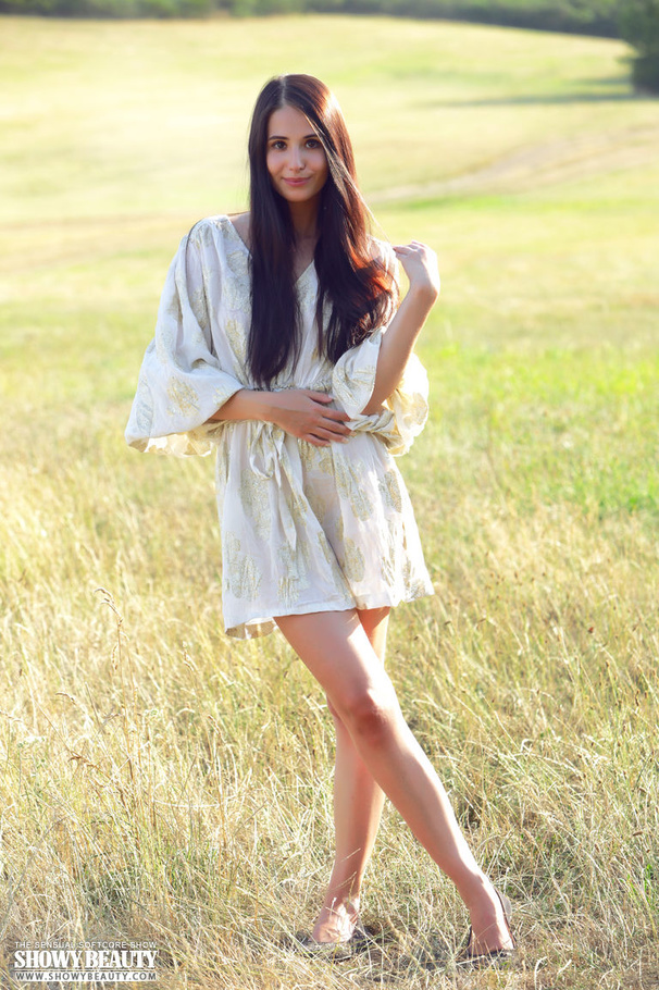 Pretty young babe lifts up her skirt and reveals her lusty pussy before she takes off her white robe and seduces with her small tits and skinny body as she pose naked on a grassy field. - XXXonXXX - Pic 1