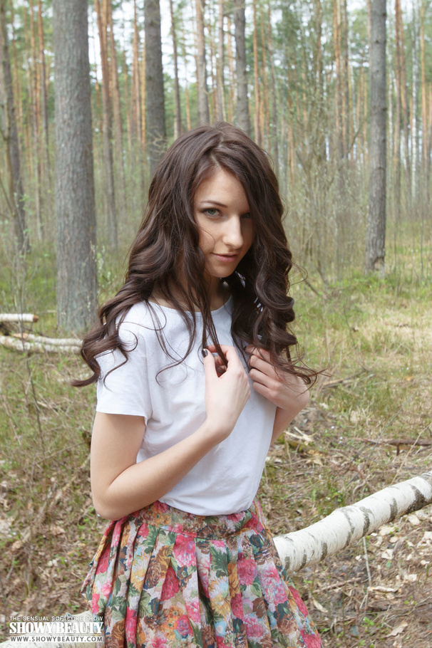 Lovely brunette goes in the woods then peels off her white shirt and shows her sweet boobs before she opens her legs wide and bares her indulging pussy as she strips off her multi-colored skirt while she sits on a bamboo bench. - XXXonXXX - Pic 1
