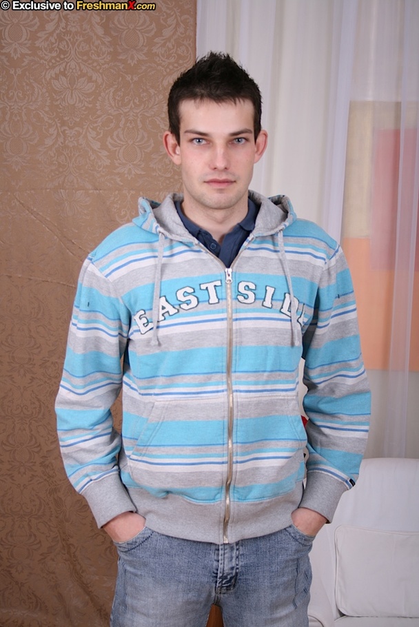 Hot stud takes off his blue and gray jacket then peels down his jeans and blue and white brief and expose his big cock in different poses on a white couch wearing his blue shirt. - XXXonXXX - Pic 1
