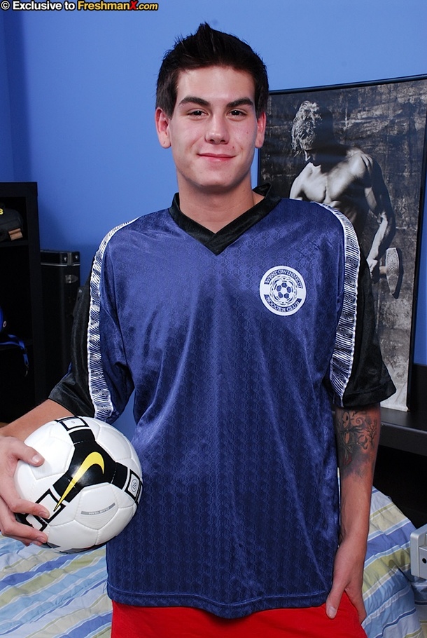 Gorgeous guy in soccer uniform peels off his blue shirt and displays his huge body as he lays down on a yellow, blue and white striped bed before he pulls down his red shorts and white underpants then lays down and jacks his cock. - XXXonXXX - Pic 1