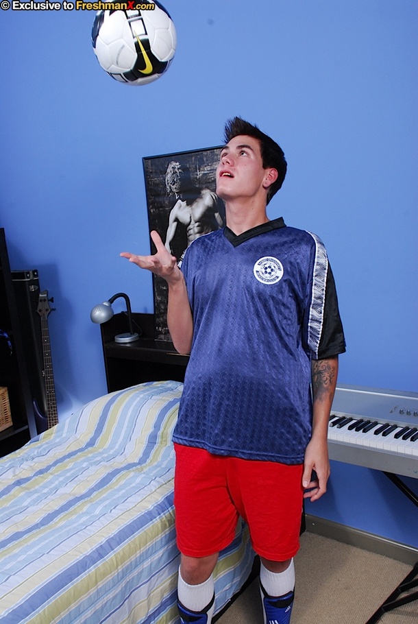 Soccer athlete lays down on a blue, white and yellow striped bed then takes off his blue shirt and red shorts and expose his stud body while he sits on a his black and white ball before he removes his white cycling pants and expose his large cock. - XXXonXXX - Pic 3
