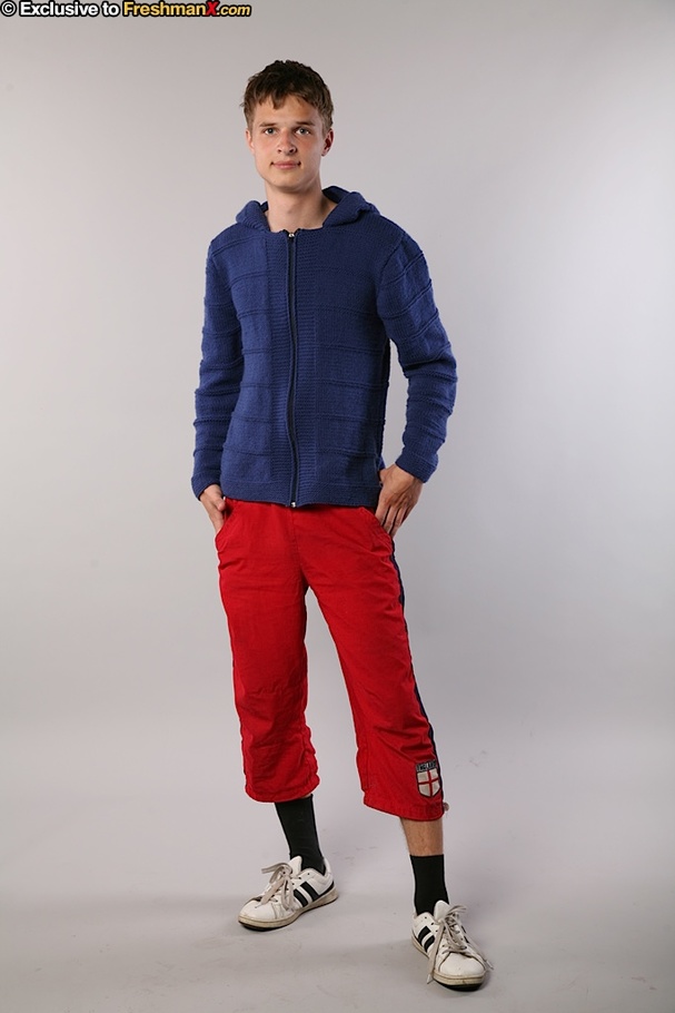 Handsome hottie peels off his blue jacket and red jogging pants then peels down his black brief and displays his big dick in different poses in a white studio. - XXXonXXX - Pic 1