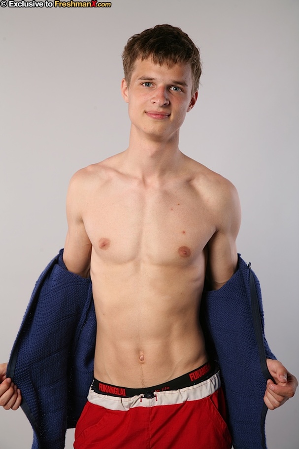 Handsome hottie peels off his blue jacket and red jogging pants then peels down his black brief and displays his big dick in different poses in a white studio. - XXXonXXX - Pic 3