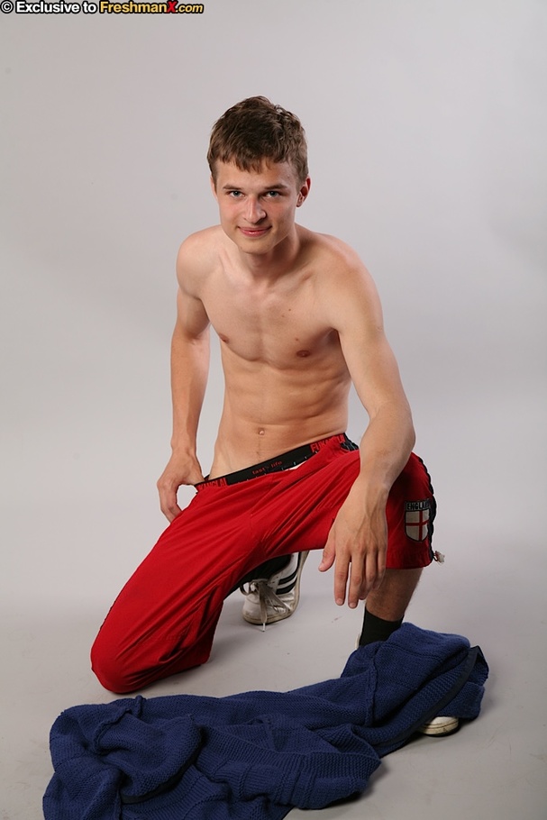 Handsome hottie peels off his blue jacket and red jogging pants then peels down his black brief and displays his big dick in different poses in a white studio. - XXXonXXX - Pic 5