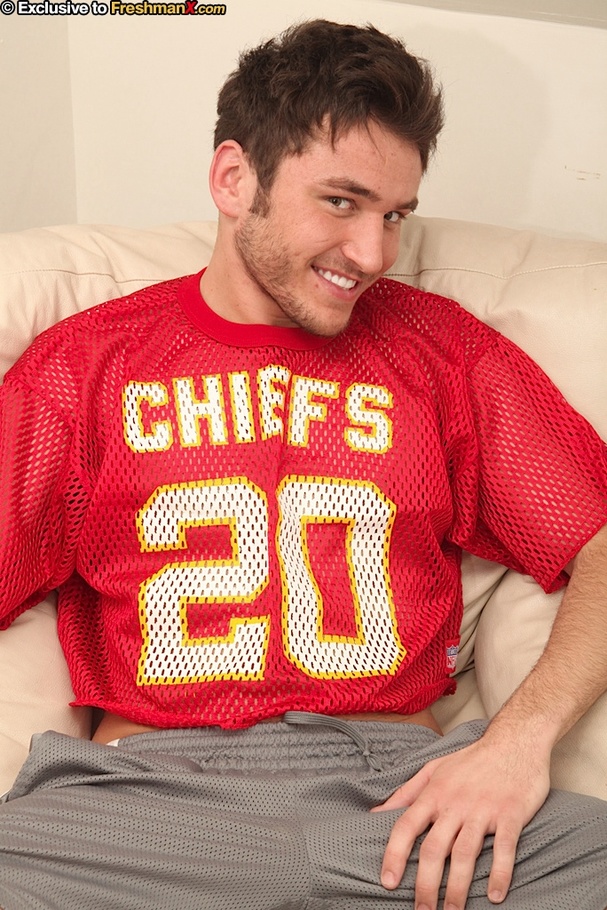 Gay stud sits on a light brown couch and takes off his red shirt and gray shorts then shows his stud body as he lifts some weights before he takes off his black pants and jacks off. - XXXonXXX - Pic 1