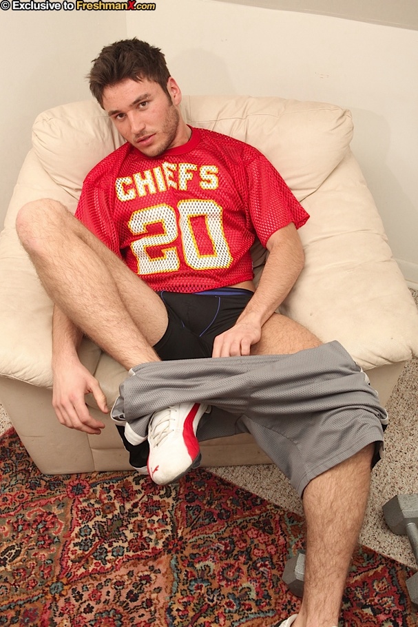 Gay stud sits on a light brown couch and takes off his red shirt and gray shorts then shows his stud body as he lifts some weights before he takes off his black pants and jacks off. - XXXonXXX - Pic 2