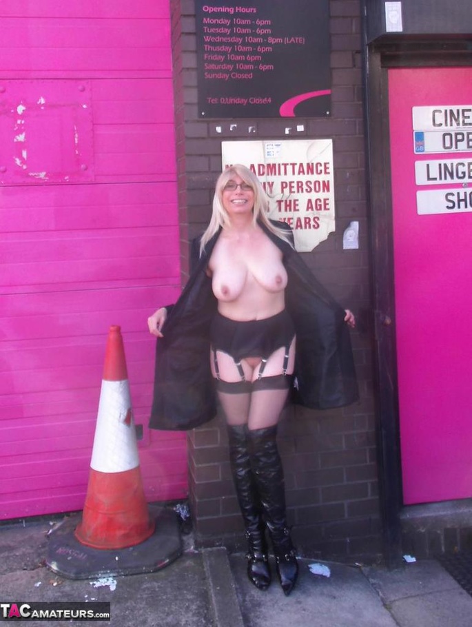Blonde slut shows her massive tits while posing in a sex shop - XXXonXXX - Pic 1