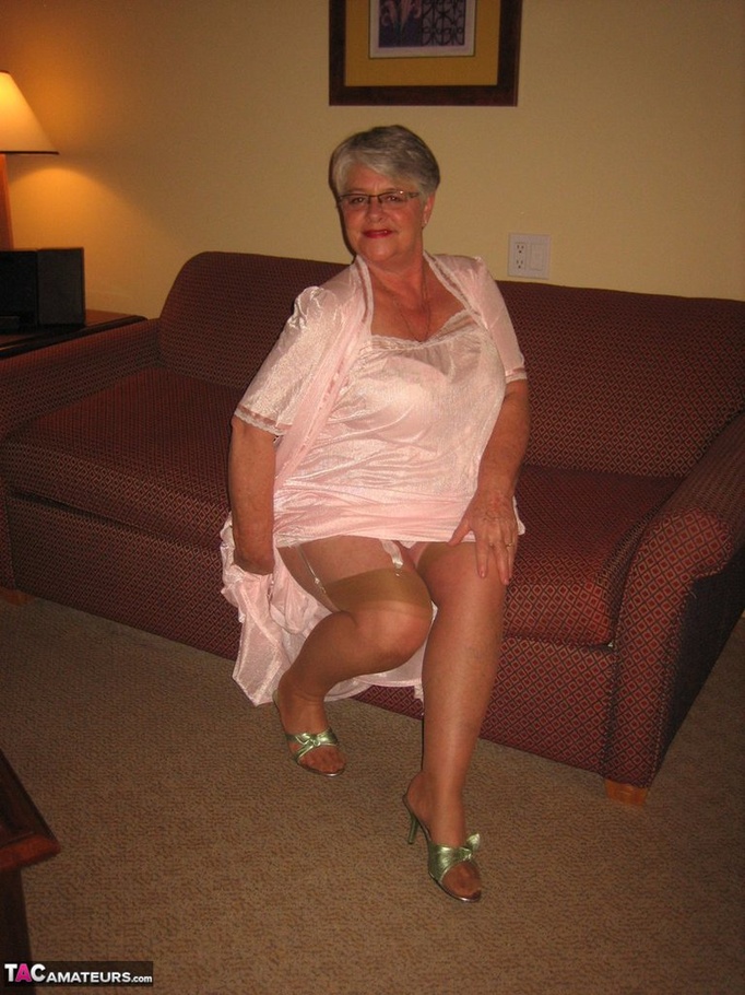 Nice Elderly Blonde With Short Hair Wearing Soft Pink Silk Night Gown And Robe Shows Off The