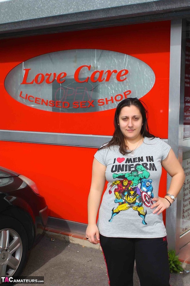 [Cute babe pose her chubby body in gray shirt, black jogging pants and boots in a sex shop before she gets naked and puts on her violet and black nighty, black stockings and high heels in a fitting room. - XXXonXXX - Pic 1