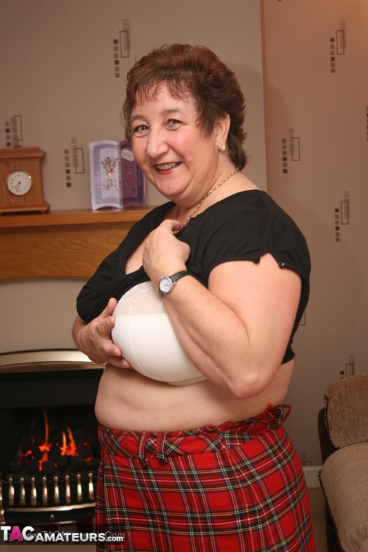 Mature babe peels off her black shirt and red skirt then teases with her super size body in different poses wearing her white lingerie, black stockings and high heels on a brown couch. - XXXonXXX - Pic 11