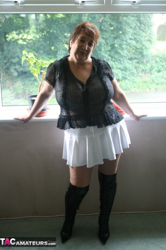 Hot granny peels off her black blouse and teases with her plus size body then shows her gigantic breasts wearing her white lingerie, skirt and black boots in different poses. - XXXonXXX - Pic 1