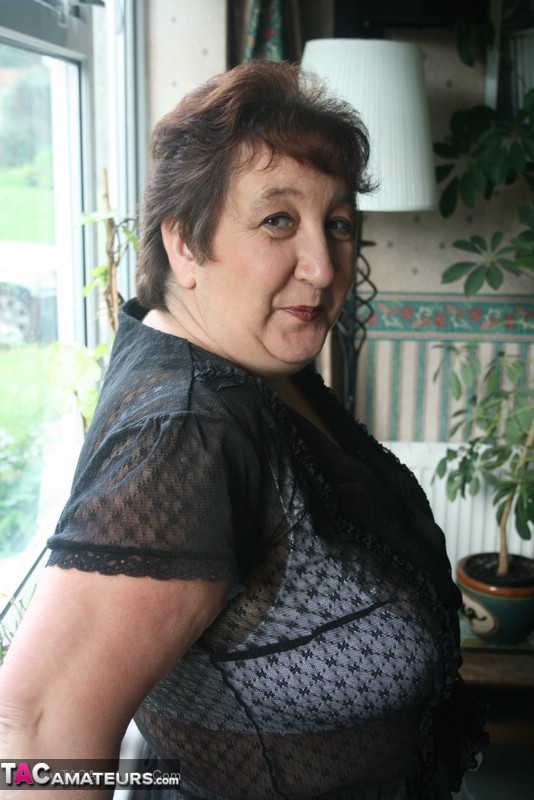 Hot granny peels off her black blouse and teases with her plus size body then shows her gigantic breasts wearing her white lingerie, skirt and black boots in different poses. - XXXonXXX - Pic 2