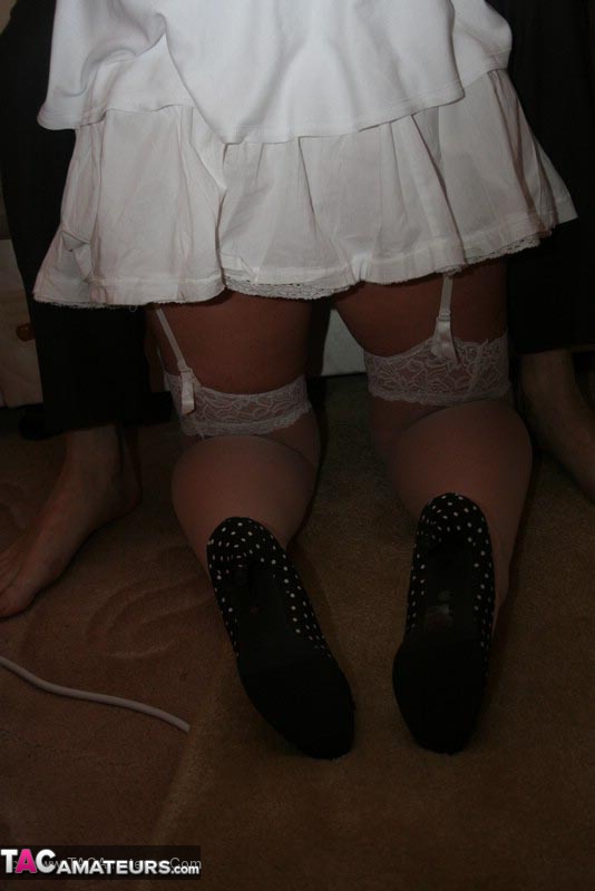 Mature BBW teases her horny hubby with her large body in white dress, lingerie, stockings and black high heels before she gets on her knees and wanks his cock on a brown bed. - XXXonXXX - Pic 15