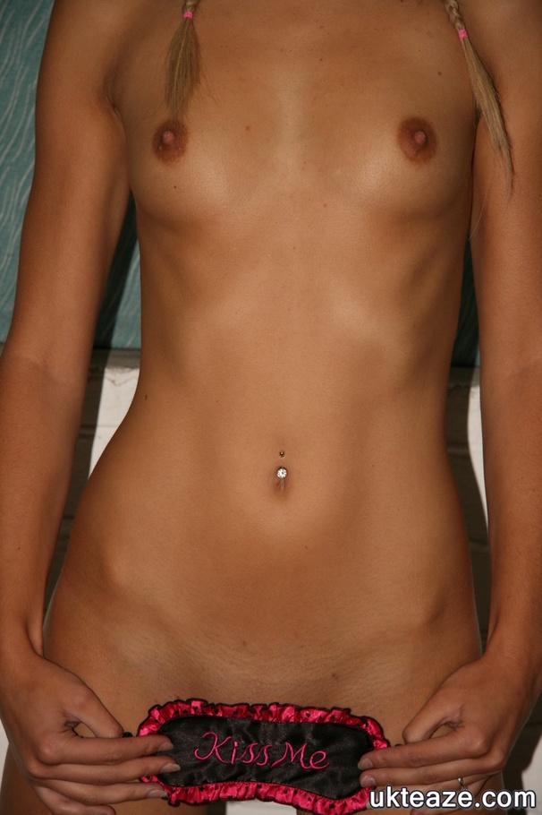 Blonde chick in pigtails wearing pink and black lingerie and white and brown high heels teases with her skinny body before she peels off her bra and shows her sweet boobs then pulls down her panty and shows her juicy pussy in different poses on a black chair. - XXXonXXX - Pic 15