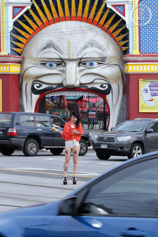 Foxy chick displays her smoking hot body while she eats her burger and fries as she walks around the street wearing her orange shirt, puple bra, white shorts and black high heels. - XXXonXXX - Pic 3