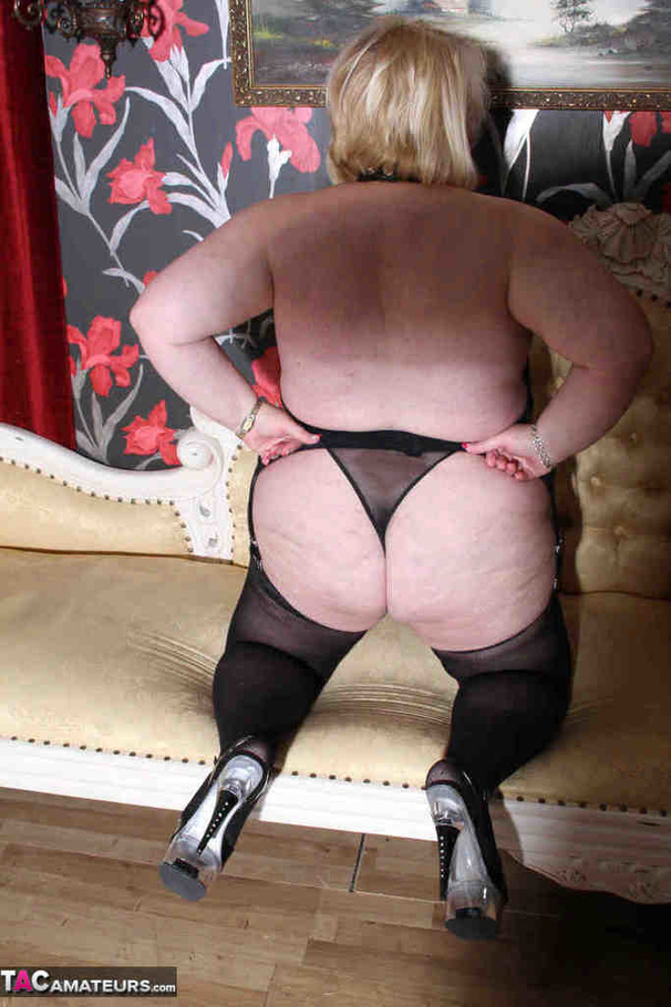 Plump blonde in black stockings wiggles out of black lingerie before riding red dildo on the couch - XXXonXXX - Pic 1