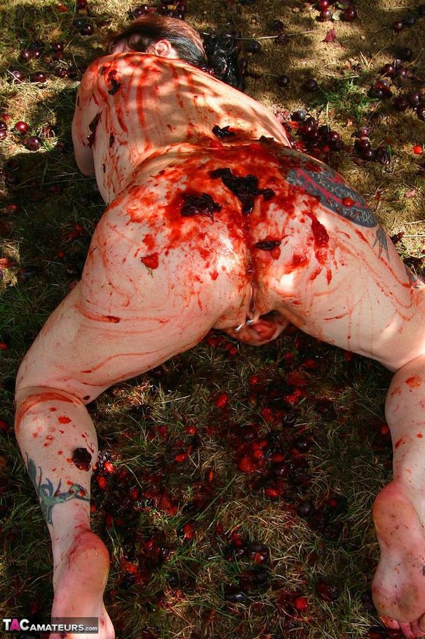 Chubby brunette with big tits gets her tattooed body covered with plums while posing on the ground outdoors - XXXonXXX - Pic 7