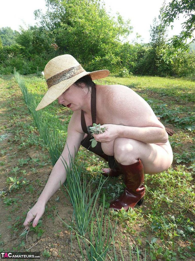 Dark haired wife with huge hooters working in the garden and showing her shaved pussy while posing in rubber boots - XXXonXXX - Pic 9