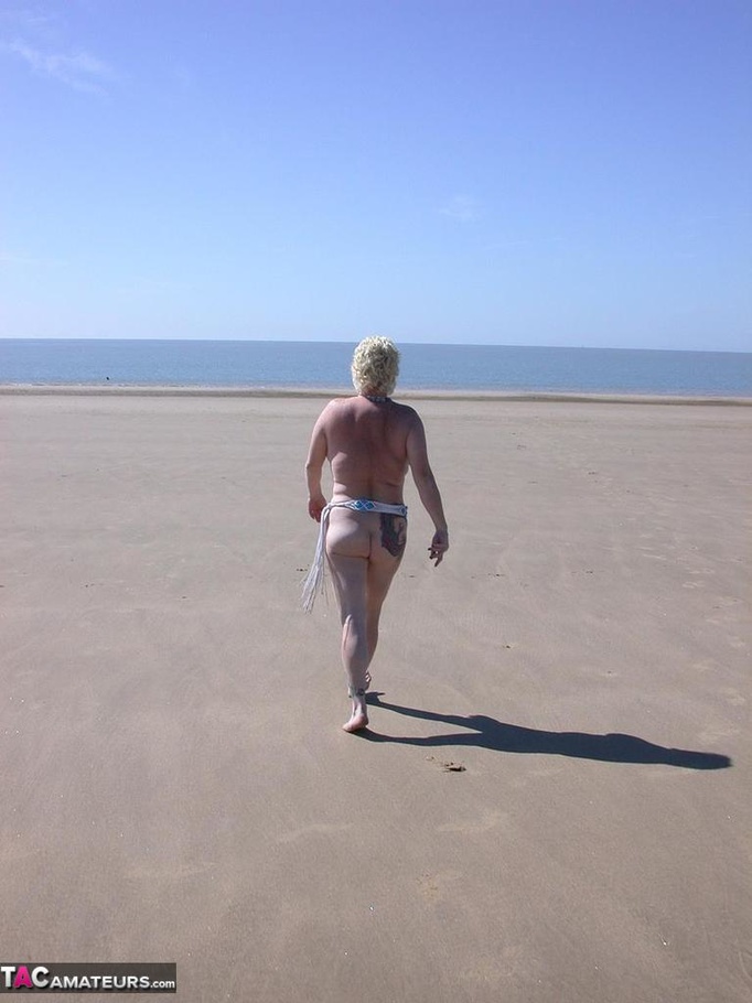 Mature blonde in white top and jeans miniskirt peeing outdoors before exposing her huge breast on the beach - XXXonXXX - Pic 13