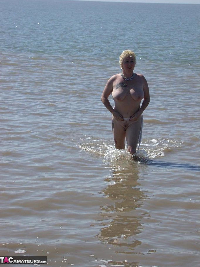Mature blonde in white top and jeans miniskirt peeing outdoors before exposing her huge breast on the beach - XXXonXXX - Pic 19