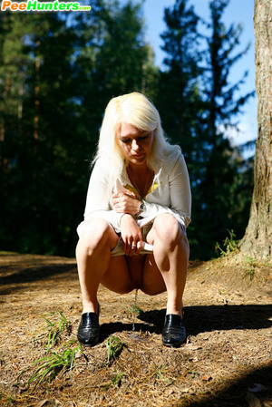 Naughty blonde pisses into a sandpit in forest - Picture 8