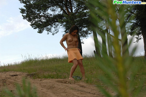 Naughty brunette pisses into a sandpit in forest - Picture 12