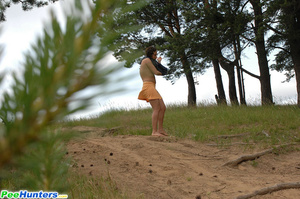Naughty brunette pisses into a sandpit in forest - Picture 14