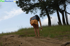 Naughty brunette pisses into a sandpit in forest - Picture 15