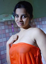 Smily indian stunner in sexy red dress seductively posing in the restroom.