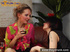 Blond girl in pink blouse and miniskirt drinks wine with her boyish girlfriend