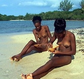 Sitting on the beach and doing something interesting with their ebony