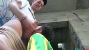Swarthy guy sucking his lover's cock kneeling outdoors