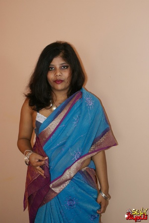 Cool pics with a real Indian girl in a blue sari undresses to expose her chubby delights on cam - Picture 1