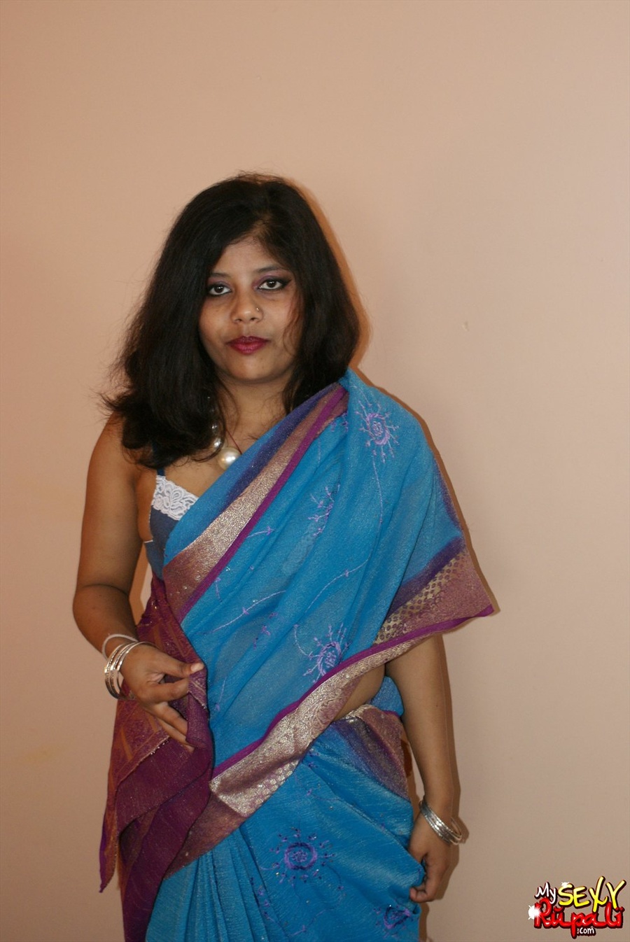 Cool pics with a real Indian girl in a blue sari undresses to expose her chubby delights on cam - XXXonXXX - Pic 1