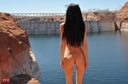 Very slim brunette teen in a black latex suit posing in the rocks when gets naked