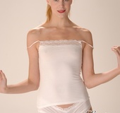 Small-titted blonde girl in white top and panties gets nude in front of