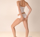 Lovely blonde chick with small tits pulls down her white panty and poses