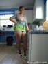 Blonde housewife in a green skirt and black stockings demonstrating her