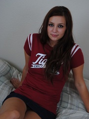 Busty teen in a cheerleader T-shirt stretches her cooch - Picture 1