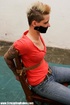 Short-haired chick in a red T-shirt and jeans gets her mouth stuck with