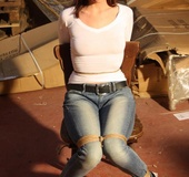 Hot red chick in jeans with a gag-ball gets roped tightly to the chair